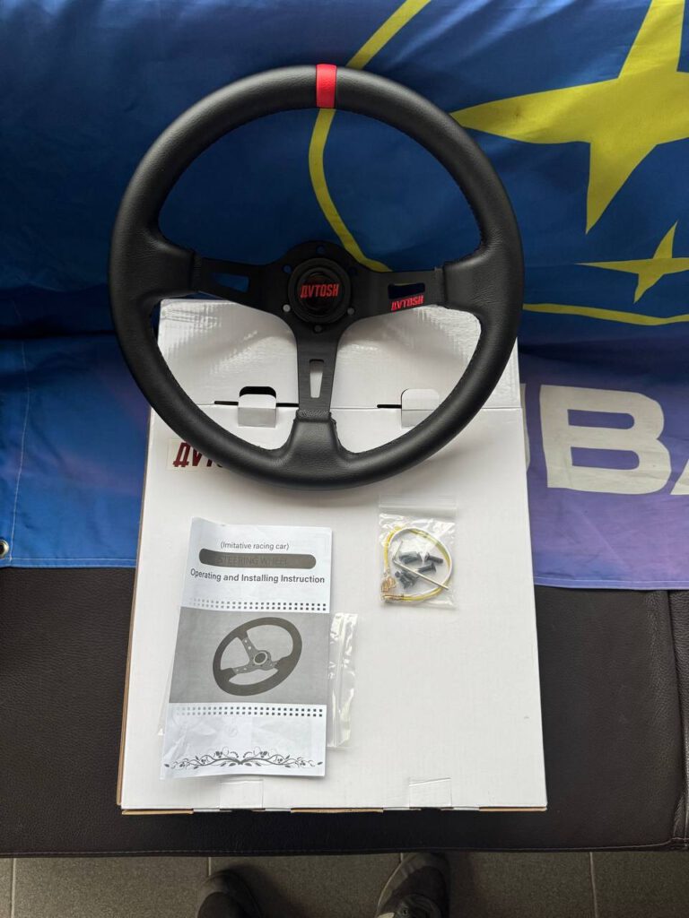 Avtosh black leather sport steering wheel shown with its box, instruction booklet and visible accessories.