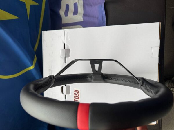Upper side detail showing the red centre marker and leather stitching on the steering wheel rim.
