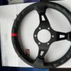 Rear view of the steering wheel showing the black spokes, leather rim and centre mounting holes.